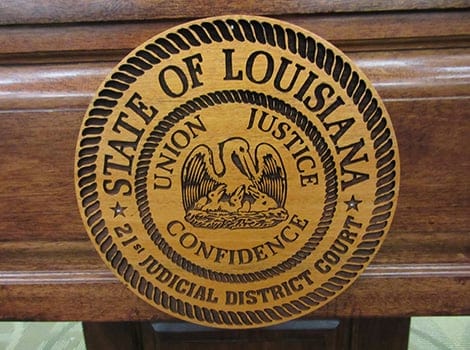 Wooden Louisiana state seal with a pelican and the words “Union, Justice, Confidence” for the 21st Judicial District Court.