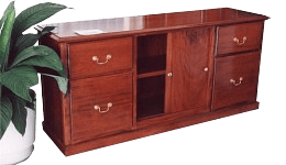 A wooden sideboard with four drawers, two open shelves in the center, and brass handles, positioned next to a leafy potted plant.