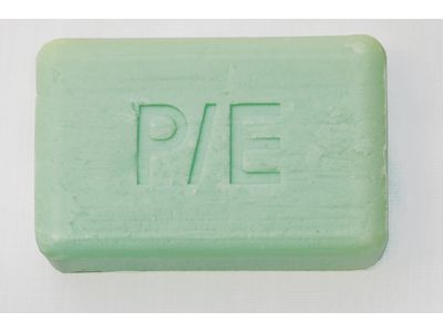 A rectangular green bar of soap with the letters "P/E" engraved on its surface.