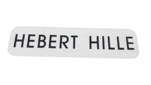 A white plastic nameplate with rounded corners shows "HEBERT HILLE" in bold uppercase black letters.