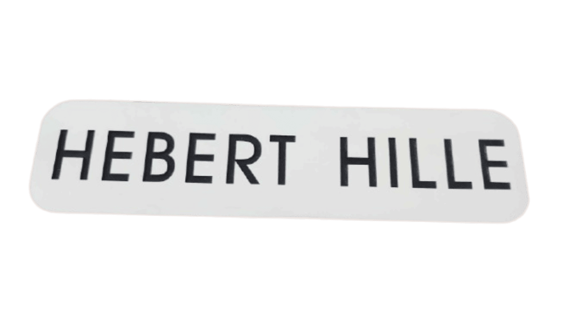A white plastic nameplate with rounded corners shows "HEBERT HILLE" in bold uppercase black letters.