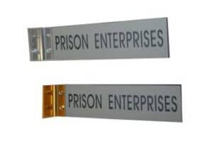 Two "PRISON ENTERPRISES" Wall Bracket End Mountings, each with a different colored hinge, displayed on a white background.