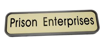 A Modular Wall Frame w/ Nameplate featuring "Prison Enterprises" in bold black letters on a light background.