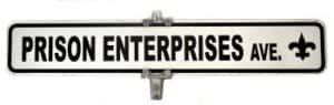 A street sign reads “PRISON ENTERPRISES AVE.” with a fleur-de-lis symbol on the right side.