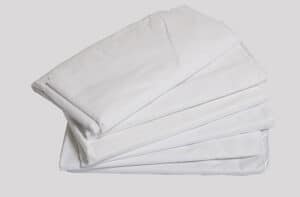 Five Percale Bed Sheets 66"L X 104"W, neatly folded and stacked against a plain, light background.