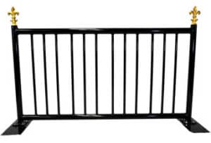 The Barricade (8') is a black metal barrier with vertical bars and gold fleur-de-lis finials on both top corners.