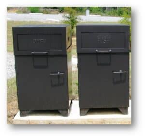 Two Flap Open Trash Receptacles with "PUSH" lids, black, side by side on a concrete outdoor slab.