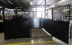 Open Livestock Panels with vertical bars are installed inside an industrial warehouse with concrete floors and overhead lighting.