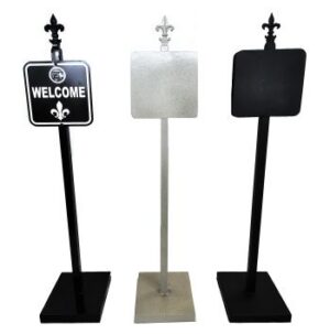Three Ornamental Sign Post (4') with square plaques: black "Welcome," plain silver, and plain black; fleur-de-lis finials.