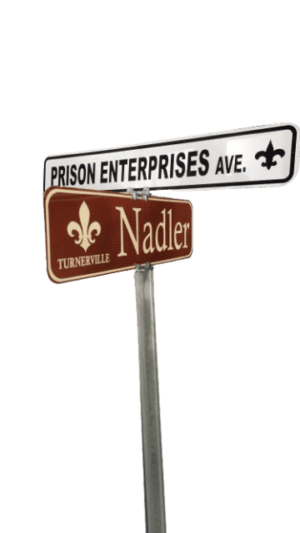 .080 Aluminum Street Sign reading "Prison Enterprises Ave." at intersection with "Nadler" and "Turnerville," featuring a fleur-de-lis symbol.